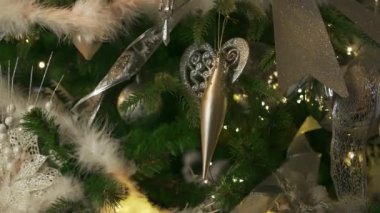 Kadın yeşil kabarık bir Noel ağacına parlak bir yılbaşı topu asıyor. Kadın elleri, yaklaşın. Ağır çekim. Noel kış tatili konsepti. Şenlik havası. Kadın elleri, yaklaşın. Yavaş çekim.