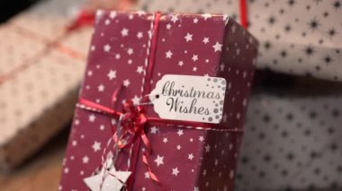 Noel ağacının yanında parlak bir çelenk ve toplarla süslenmiş güzel hediye kutuları var. Hediye kutusuyla yeni yıl geçmişi. Noel 'i kutluyoruz. Şenlik havası. Kapatın. Yavaş çekim.