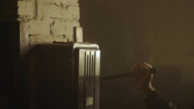 Endüstriyel bir santralde jeneratör anahtarı. Bir adam elini kapatır ve yumuşak bir sahne ışığı olan dumanlı karanlık bir odada jeneratörün düğmesini açar. Kapat..