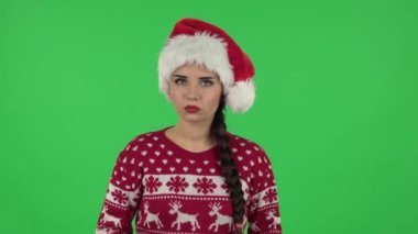 Noel Baba şapkalı tatlı kızın portresi bilgi dinliyor, şok oluyor ve 
