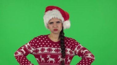 Noel Baba şapkalı tatlı kız yumrukla tehdit ediyor. Yeşil Ekran