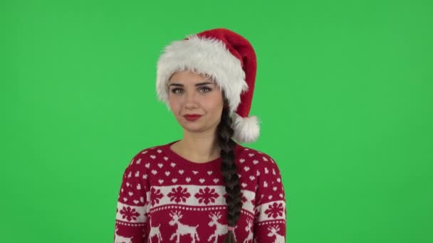 Портрет солодкої дівчинки в капелюсі Санта Клауса розважається. Зелений екран — стокове відео