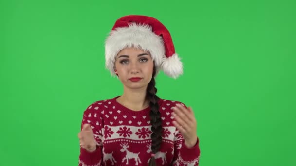 Portret słodkiej dziewczyny w kapeluszu Świętego Mikołaja klaska jej ręce obojętne. Zielony ekran — Wideo stockowe