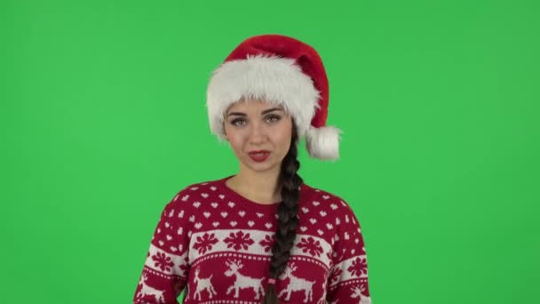 Ritratto di ragazza dolce in cappello di Babbo Natale sta segnalando e raccontando un sacco di informazioni interessanti. Schermo verde — Video Stock