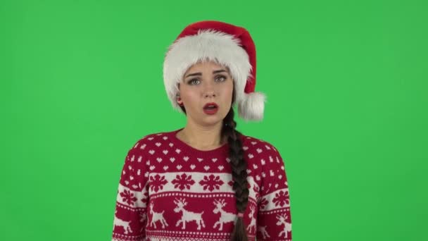 Noel Baba şapkalı tatlı kızın portresi gücenmiş ve gülümsüyor. Yeşil Ekran — Stok video