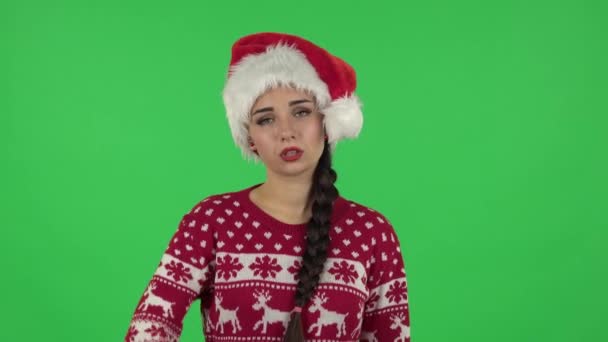 Portret słodkiej dziewczyny w kapeluszu Świętego Mikołaja jest zdenerwowany i zmęczony. Zielony ekran — Wideo stockowe