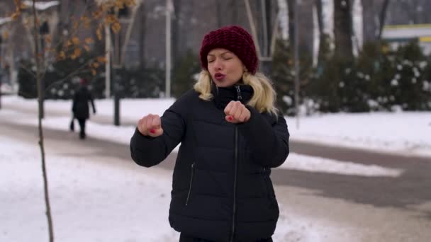 Egy fiatal nő, miután hallotta a jó hírt, vicces táncot jár a téli város utcáin. Az örömteli lány ünnepli a sikert, meglepődik. Közelről. Lassú mozgás.. — Stock videók