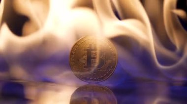 Siyah bir arka planda, bir alev altın bir bitcoin sikkeyi yakın planda tutuşturur ve aydınlatır. Kripto para birimi yanıyor, borsa parası yanıyor. Karanlıkta parlayan tehlikeli ateş. Yavaş çekim.