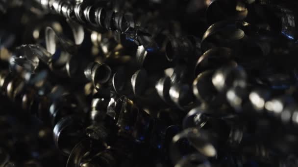 Macro shot des copeaux de métal, qui peuvent être en fer, en aluminium ou en acier. Fond de copeaux métalliques. Spirales métalliques bouclées, recyclage industriel. Fermer les copeaux torsadés en spirale d'acier. Mouvement lent. — Video
