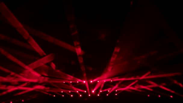 Färgglada strålar av rött scenljus i rökig mörk studio. Röda strålkastare. Belysningsutrustning och ljuseffekter för design, konsertsal och scenbelysning under show eller disco. Närbild. Långsamma rörelser. — Stockvideo