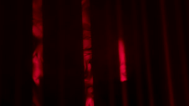 Rayos de luz láser rojo sobre un fondo oscuro ahumado. Luces láser de colores y humo en la fiesta. Iluminación de color profesional y efectos de espectáculo de sonido. Fondo de luces de concierto. De cerca. Movimiento lento. — Vídeos de Stock