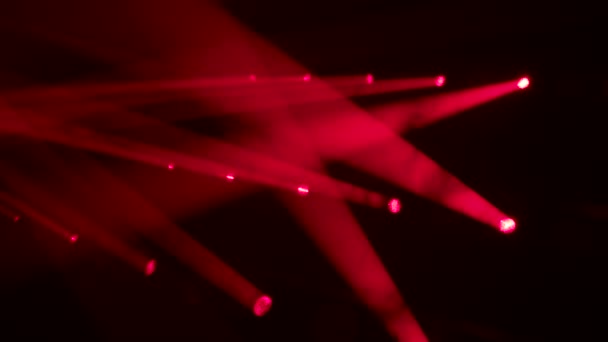 Colorful beams of red stage light in smoky dark studio. Red spotlights. Lighting equipment and light effects for design, concert hall and stage lighting during show or disco. Close up. Slow motion. — Vídeo de Stock