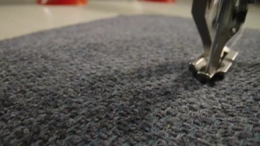 Gri yün kumaşı dikiş makinesiyle dikerken ayak ve iğne hareketleri. Dikiş makinesinin gümüş ütülü ayağı kumaşı bastırır ve iğneyle diker. Kapatın. Yavaş çekim.