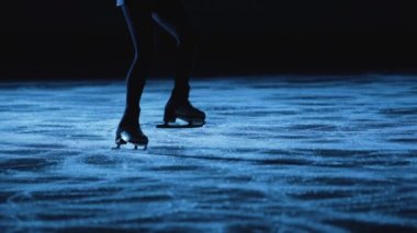 Artistik patinajcı kadın buz pistinde paten kayıyor, geceleri mavi ışıkta antrenman yapıyor. Genç bir kadın yarışmaya hazırlanıyor, atlama eğitimi alıyor ve kayıyor. Ağır çekimde, bacaklar patenlerle yakın..