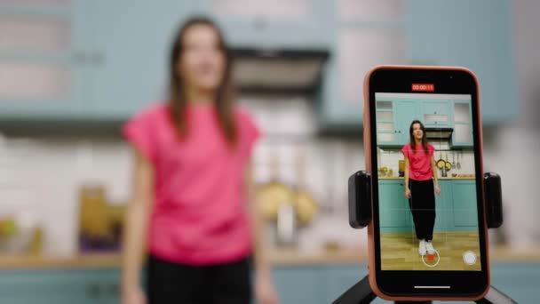 Dos chicas jóvenes bailando, cantando, divirtiéndose y filmando vídeos para sus blogs o redes sociales. Los bloggers están grabando vlog con contenido de tendencia en la cocina. Cámara lenta lista, 4K a 59.97 fps. — Vídeo de stock