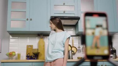 Genç kız, blogları ya da sosyal ağları için dans edip video çekiyor. Blogcu, medya hesabı için mutfakta trend içerikli vlog kaydediyor. Ağır çekim hazır, 4K 59.97 fps 'de..