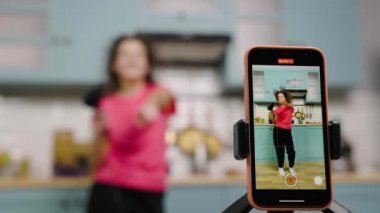 Genç kız dans ediyor, saç kurutma makinesi kullanarak şarkı söylüyor ve blog ya da sosyal ağ için video çekiyor. Medya hesabı için mutfakta trend içerikli blog kaydı. Ağır çekim hazır, 4K 59.97 fps 'de..