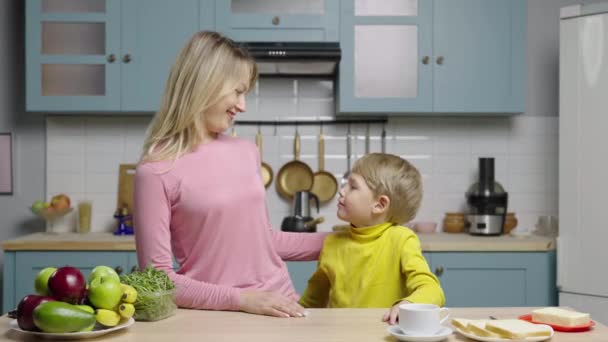 Fiatal nő és fiú ölelkeznek a konyhában. Lassú mozgás kész, 4K 59.97fps-en.. — Stock videók