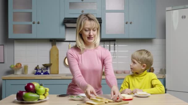 Frau bringt Junge bei, wie man Sandwiches backt, indem man Butterbrot backt. Mutter und Sohn filmen Geschichten in der Küche für den Social-Media-Kochblog. Familienblogger, Kulinarik. Zeitlupe bereit, 4K bei 59.97fps. — Stockvideo