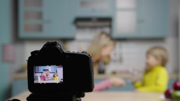 Focus op het camerascherm met vrouw en jongen die plezier hebben met dansen en grappige video maken. Mam en zoon filmen verhalen in de keuken voor social media koken blog. Bloggers. Slow motion klaar, 4K bij 59,97 fps. — Stockvideo