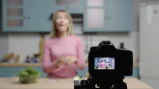 Молода жінка розмовляє з камерою про переваги використання натуральних продуктів замість очних латок. Жіночий блогер, який знімає історії на кухні для блогу краси соціальних мереж. Повільний рух готовий, 4K на 59.97fps . — стокове відео