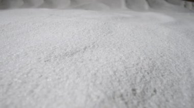 Kamera kuru beyaz kum tepeciklerinin üzerinde döner. Kumlu kum tepeciklerinin ışıkta parlayan kum tanecikleriyle yakın çekimi. Saf doğal kuvars taneleri. Ağır çekim hazır, 4K 59.97 fps 'de..