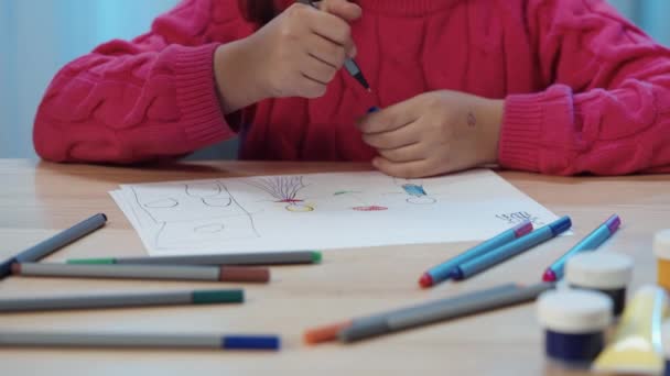 Petite écolière assise à la table dans la pièce et dessinant avec des stylos feutre dans l'album. Une adolescente est engagée dans la créativité, dessine un tableau. Ferme là. Prêt au ralenti, 4K à 59.94fps. — Video