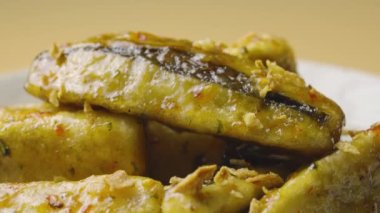 Tempura patlıcan dilimleri, baharatlı baharatlar ve gri tabakta kamış şekeri şurubu, yakından dönüyor. Sıcak baharat ve sarımsaklı yağda kızartılmış patlıcan parçaları. Asya restoranının mutfağı. Yavaş çekim.