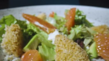 Greyfurtlu salata, yeşil marul, avokado, ton balığı ve peynirli sandviç. Restoran yemekleri, sağlıklı yemekler. İtalyan salatası. Fransız mutfağı. Kamera yavaş çekimde yakınlaştır.