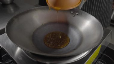 Baharatlı ve sarımsaklı yağ önceden ısıtılmış tavaya dökülüyor ve tempura içinde patlıcan parçaları dökülüyor. Baharatlı sebze, Asya patlıcan yemeği pişiriyorum. Tavayı yaklaştır. Yavaş çekim.