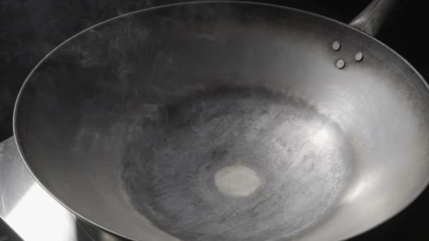 Una sartén wok de hierro fundido al rojo vivo está fumando y calentándose en la estufa de cerca. Sartén vacía en la estufa. La sartén está siendo preparada para freír y cocinar comida asiática. Cocina china. Movimiento lento. — Vídeos de Stock