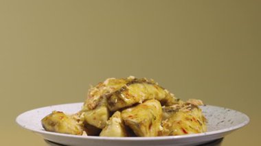 Tempura patlıcan dilimleri, baharatlı baharatlar ve gri tabakta kamış şekeri şurubu, yakından dönüyor. Sıcak baharat ve sarımsaklı yağda kızartılmış patlıcan parçaları. Asya restoranının mutfağı. Yavaş çekim.