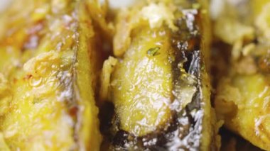 Kamera çıtır patlıcan tempura dilimlerini sıcak baharat ve kamış şurubuyla kaplıyor, yakın çekim. Asya mutfağı, Japon baharatlı sebzeler. Çin ulusal el yapımı yemek. Restoran servis edildi. Yavaş çekim.