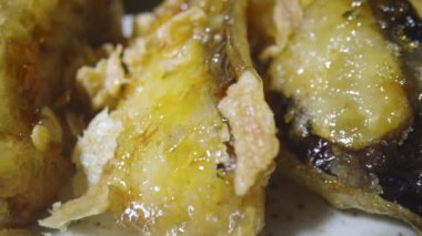 Kamera çıtır patlıcan tempura dilimlerini sıcak baharat ve kamış şurubuyla kaplıyor, yakın çekim. Asya mutfağı, Japon baharatlı sebzeler. Çin ulusal el yapımı yemek. Restoran servis edildi. Yavaş çekim.