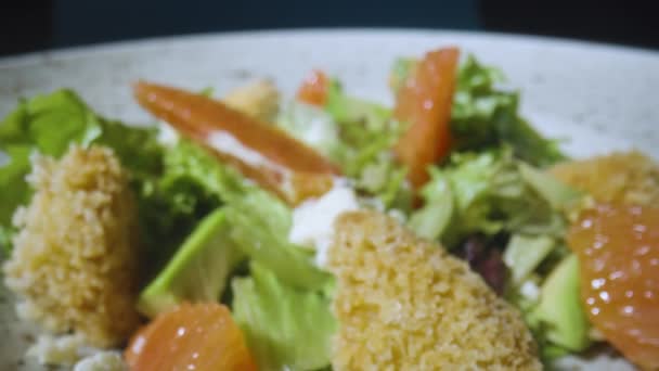 Salad with grapefruit, green lettuce, avocado, tuna and cheese on gray plate close up. Restaurant food, healthy dish. Italian salad. French cuisine. Camera zoom in slow motion. — Stock Video