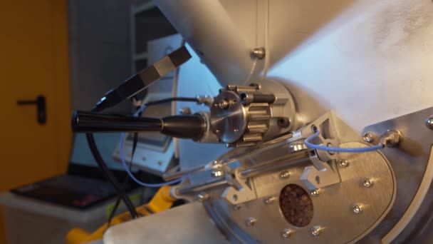 Homme barista vérifie les grains de café pour le degré de torréfaction et d'arôme. Grille-pain industriel professionnel vérifie rôti. Machine à rôtir fermer. Fond de nourriture et de boissons pour café. Mouvement lent. — Video