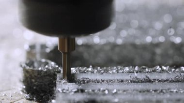 Metal fabrikası kapanıyor. Fabrikada metal parçaları üretiyor. Metal işçiliği için makine aletleri. Metal bir iş parçası elektrikli bir makine tarafından düzenlenir. Etrafta talaşlar uçuşuyor. Yavaş çekim.