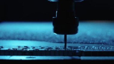 Metal fabrikası. Sondaj çeliği, yavaş çekim. Sondaj makinesi metali işliyor, şekli kesiyor. Detayların modern işleme teknolojisi. Endüstriyel detayları mavi ışıkta kapatıyoruz.