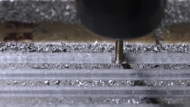 Fresadora metalúrgica de cerca. Produce detalles metálicos en una fábrica. Máquinas herramienta para trabajar el metal. Una pieza de metal es mecanizada por una máquina eléctrica. Los afeitados vuelan por ahí. Movimiento lento. — Vídeos de Stock