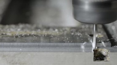 CNC matkabı ile torbalama sırasında alüminyumdan bükülmüş metal parçaları uçar. Yüksek teknolojili bir makine atölyesinde çeliği kesme sürecinde olan bir değirmen makinesi. Detayları kapat. Yavaş çekim.
