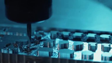 Metal fabrikası. Sondaj çeliği, yavaş çekim. Sondaj makinesi metali işliyor, şekli kesiyor. Detayların modern işleme teknolojisi. Endüstriyel detayları mavi ışıkta kapatıyoruz.