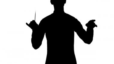 Orkestra şefinin siyah silueti batonunu beyaz stüdyo arka planında müzisyenleri yönetmek, senkronize etmek ve yönetmek için sallıyor. Görünür hareketlerle klasik müzik performansı. Kapat..