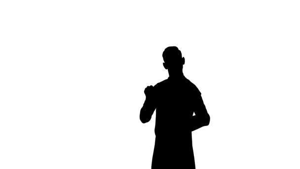 Zwart silhouet van de mens zwaait sierlijk met zijn stok om muzikanten te synchroniseren en te dirigeren. Symfonieorkestdirigent in pak op witte studioachtergrond. Sluiten.. — Stockvideo