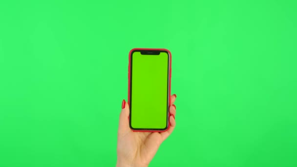 Mulher detém telefone celular com espaço de trabalho simular tela em suas mãos sobre fundo verde na posição vertical. Mão feminina tocando, clicando, tocando, deslizando, arrastando e deslizando. Fechar — Vídeo de Stock