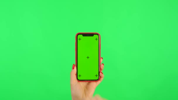 在绿色背景下，女性手持带有工作空间模拟屏幕的手机。女性的手触摸，点击，点击，滑动，滑动，滑动，放大，放大。广告区。模板的位置。靠近点. — 图库视频影像