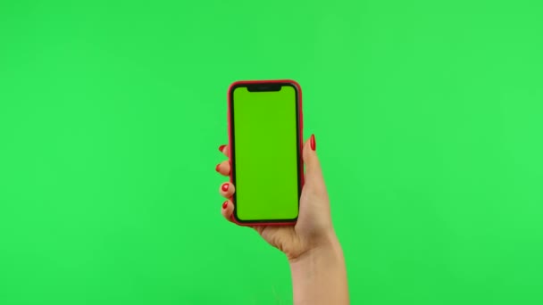La mujer sostiene el teléfono móvil con la pantalla de la maqueta del espacio de trabajo en el fondo verde en posición vertical. Mano femenina tocando, haciendo clic, deslizando y deslizando. Paquete de gestos. Área de publicidad. Lugar de la plantilla — Vídeo de stock