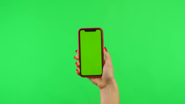 Жіноча рука тримає мобільний телефон з робочим простором, щоб маскувати екран на зеленому тлі у вертикальному та горизонтальному положенні. Варіаційний пакет позицій. Рекламна зона. Місце шаблону. крупним планом . — стокове відео