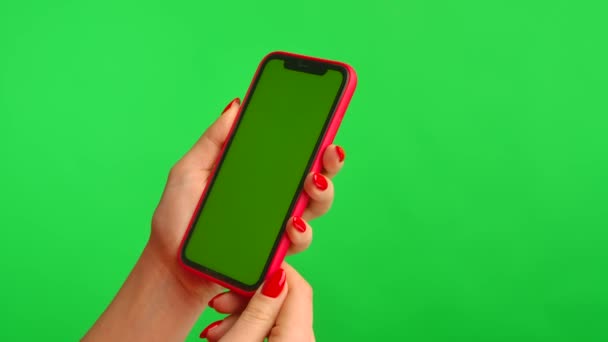 여성 손은 작업 공간을 가진 휴대 전화를 들고 녹색 배경 화면을 세로로 흔들어 놓는다. 광고 지역. 텍스트나 이미지를 위한 템플릿 장소, 프로모션 콘텐츠. 닫아. — 비디오