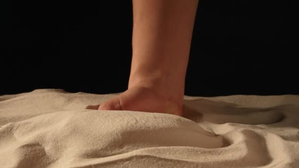 Kvinna med handfull vit torr sand i händerna, spiller sand genom fingrarna på svart studio bakgrund. Närbild av korn av ren naturlig mineral kvarts i kvinnlig hand. Långsamma rörelser. — Stockvideo