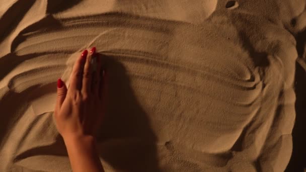 Female hand smoothing sandy surface and drawing inscription I love you. Close up of female hand is painting on the sand. Romantic holidays by sea, love, summer travel. Vacation the beach. Slow motion. — Stock Video